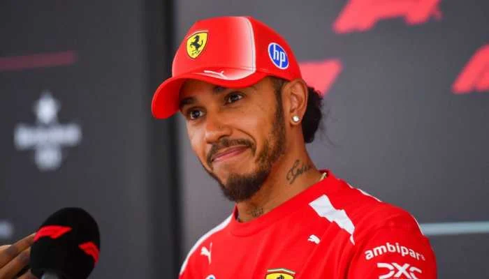 Lewis Hamilton in his 2026 Ferrari racing gear, topping the Formula 1 rich list with the highest net worth
