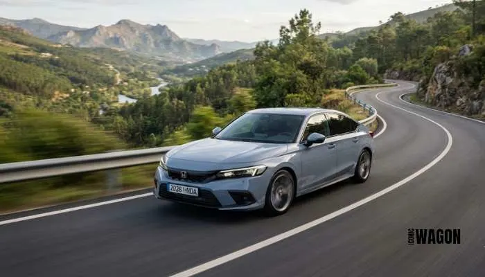 2026 Honda Civic sedan driving dynamically on a curved asphalt road